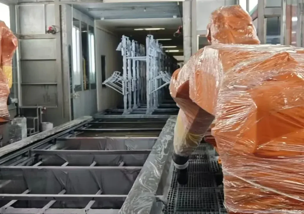 喷房内喷涂机器人对挂具工件进行粉末喷涂